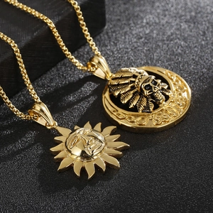 Detail of golden Indian chief skull and sun face pendants on textured background
