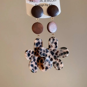 Detail of bohemian leopard print flower earrings with resin wood beads and vintage aesthetic