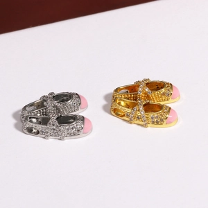 Macro detail of silver and gold ballet slipper charms with sparkling crystals and pink enamel