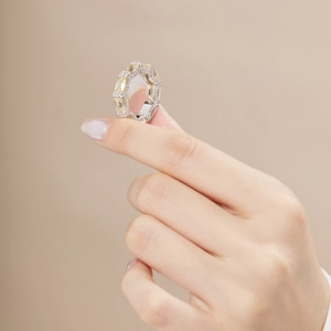 Macro shot of silver ring with radiant cut yellow gemstones and pavé set white accents