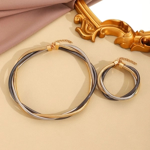 Vista piatta del set choker e bracciale in metallo intrecciato oro, argento e grigio scuro