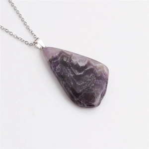 Détail du pendentif en agate violette naturelle bordé d'or sur une chaîne en acier