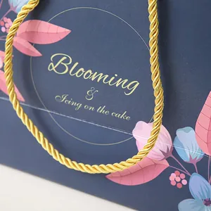 Floral dark blue gift bag with gold woven handles and Blooming text for Valentines Day