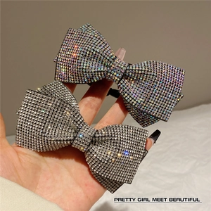 Close-up of sparkling rhinestone bow hair clips with iridescent and silver crystals