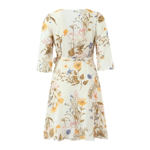 Detail of floral V-neck dress with ruffle hem and waist tie on a white background
