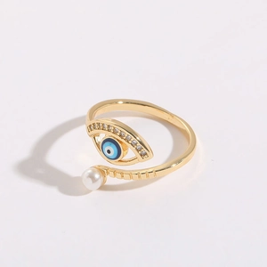 Macro detail of 14K gold plated Evil Eye ring with blue enamel and white pearl