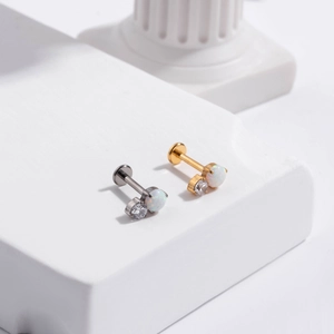 Detailed macro view of G23 titanium labret studs with white opal and cubic zirconia