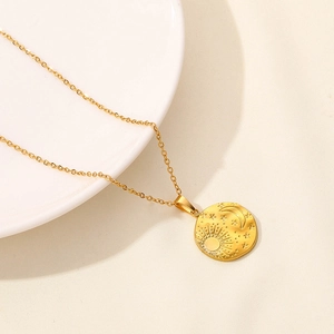 Detail of 18k gold plated celestial pendant necklace with sun moon and star engravings