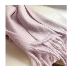 Macro shot of fluffy lavender scarf texture showing soft brushed wool and tassel detail