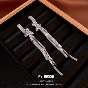 Silver knot tassel earrings with rectangular cubic zirconia on a luxury velvet display