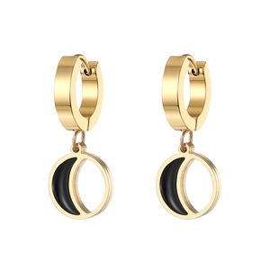 Detail of gold moon pendant earrings with black enamel inlay and polished metal finish