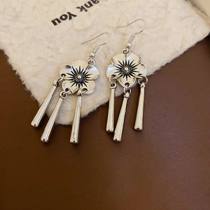 Detailed view of silver flower earrings with long fringe tassels in retro oriental style