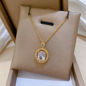 Detailed macro view of an oval gold pendant with zircon crystals on a beige cushion