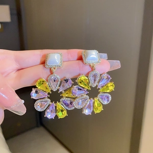 Details der Blumen-Ohrhänger mit gelben und lila Kristallen und weißen Perlen