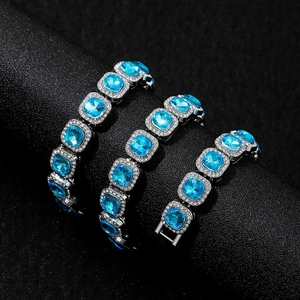 Hip hop silver link bracelets with square blue stones and pavé diamonds on a black stand