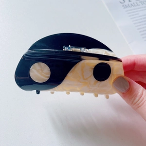 Detail of Tai Chi yin yang hair claw clip featuring black and marble acetate pattern