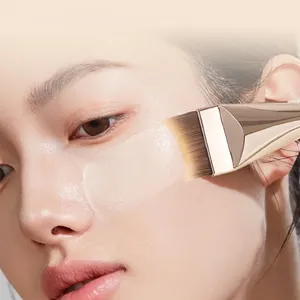 Crescent foundation brush with soft champagne gold handle for seamless makeup application