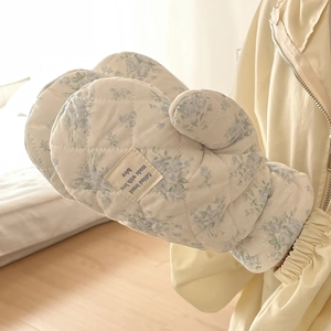 Close-up of quilted floral padded oven mitts featuring blue flowers on off-white fabric