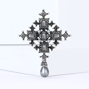 Detailed view of silver baroque cross brooch with grey crystals and teardrop pearl pendant