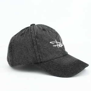 Detailed side view of washed denim baseball cap with white script embroidery