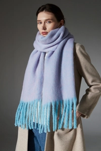 Macro shot of light purple and blue gradient loop yarn scarf with thick fringe tassels