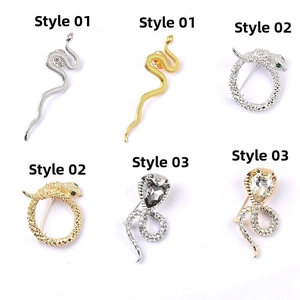 Detailed view of snake brooches in three styles featuring crystal-encrusted gold and silver finishes