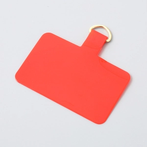 Detail view of red TPU phone tether tab with a premium gold D-ring connector