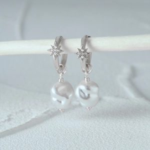 Detail of s925 silver twist hoop earrings with octagonal star and baroque pearl