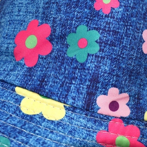 Macro view of colorful floral print texture and stitching on denim sun bucket hat fabric