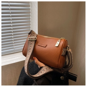 Details von brauner Leder-Zylindertasche mit buntem, breitem gewebtem Schultergurt