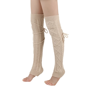 Detail of beige cable knit over-knee leg warmers featuring stylish lace-up ribbon ties