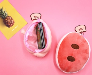 Close-up of cute pink plush pig coin purse showing soft texture and card storage detail