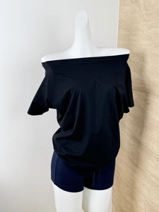 Detail view of black off-shoulder short sleeve T-shirt with layered draping on mannequin