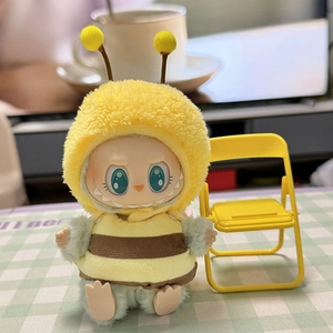 Close-up of plush doll in yellow bee costume seated by a tiny yellow folding chair