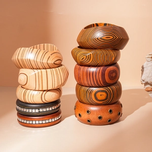 Macro detail of bohemian wooden bangles featuring geometric metal studs and natural textures