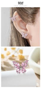 Macro detail of delicate pink crystal butterfly cartilage earrings in polished silver