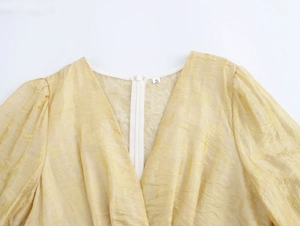 Détail d'une robe élégante à col en V avec manches bouffantes jacquard et zip au dos