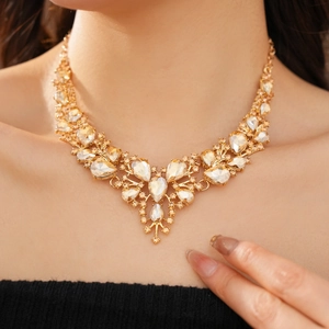 Detailed view of the V-shaped crystal necklace and teardrop earrings set on a model