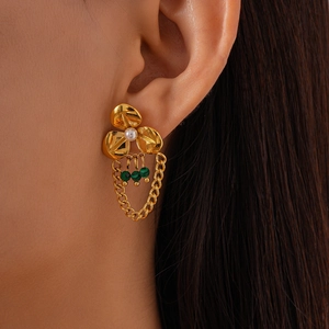 Detail of vintage flower earring with pearls, malachite beads and golden tassels