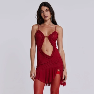 Détail de mini robe en dentelle rouge avec volants, résille et découpe sur le devant