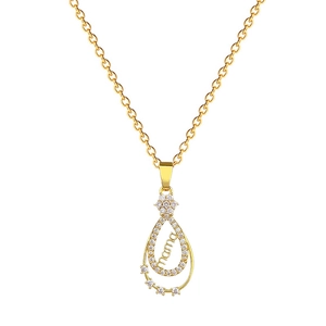 Collier goutte en or avec pavé de cristaux et lettrage mama sur fond blanc neutre
