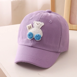 Detail of purple cotton kids baseball cap featuring cute white bear patch and side label