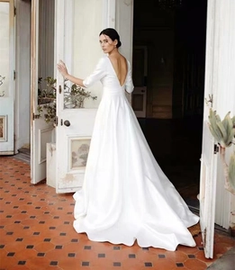 Minimalist white satin wedding dress with deep V-neck back and elegant long train