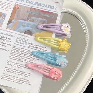 Detailed view of four colorful sea animal resin hair clips on a decorative white mirror