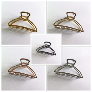 Detailed view of metal hair claw clips in gold, champagne, black, rose gold, and silver finishes