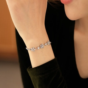 Detail of silver floral bracelet with cubic zirconia worn on wrist by a model