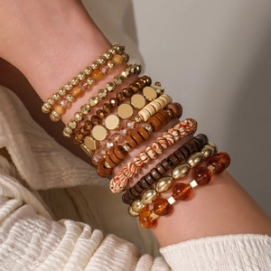 Detail of bohemian multilayer acrylic bead bracelet set with wood and metal textures