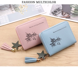 Detail view of mini zip wallets in pink and blue with star charms and tassels