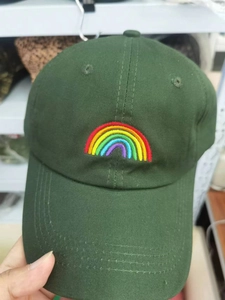 Close-up of rainbow embroidery detail on dark green cotton twill baseball cap
