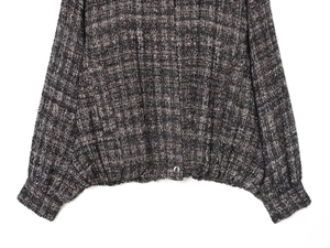 Close-up of the textured tweed bomber jacket showing fabric fibers and button detail